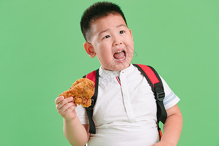 不健康食物胖子书包可爱的小男孩吃炸鸡图片