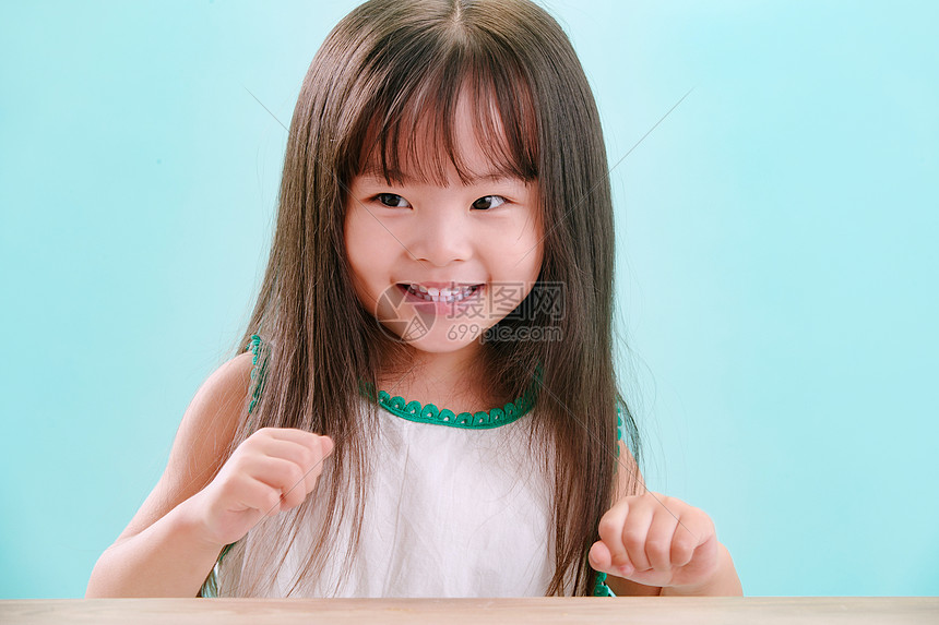 亚洲蓝色背景4岁到5岁小女孩的可爱表情图片