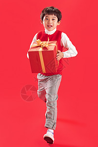 红色背景影棚拍摄摄影小男孩拿新年礼物图片