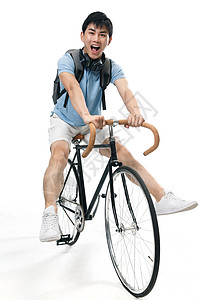 骑自行车学生耳机休闲活动愉悦年轻的大学生骑自行车背景