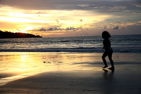 跑步的人剪影晚霞东南亚巴厘岛海滩上的孩子剪影背景