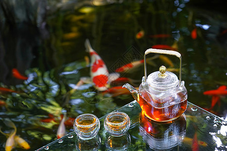 夏天池塘里的金鱼和水上的茶杯茶叶图片