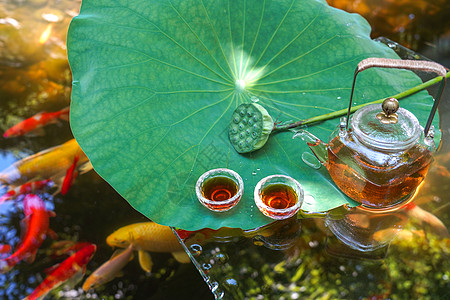 中国茶具酷暑时候的荷叶池塘和漂在水上的茶具背景