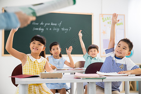 上课举手孩子上课小学女生亚洲老师和小学生们在教室里背景