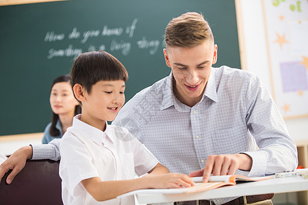 中国人群户内国际学校知识教师和小学生在教室里背景