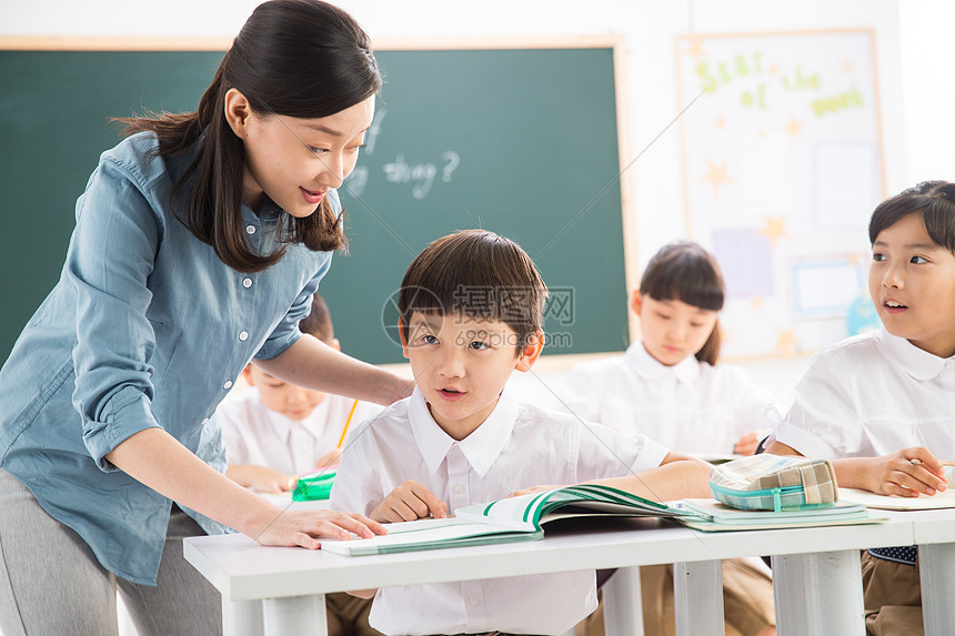 摄影相伴小学女生老师和小学生们在教室里图片