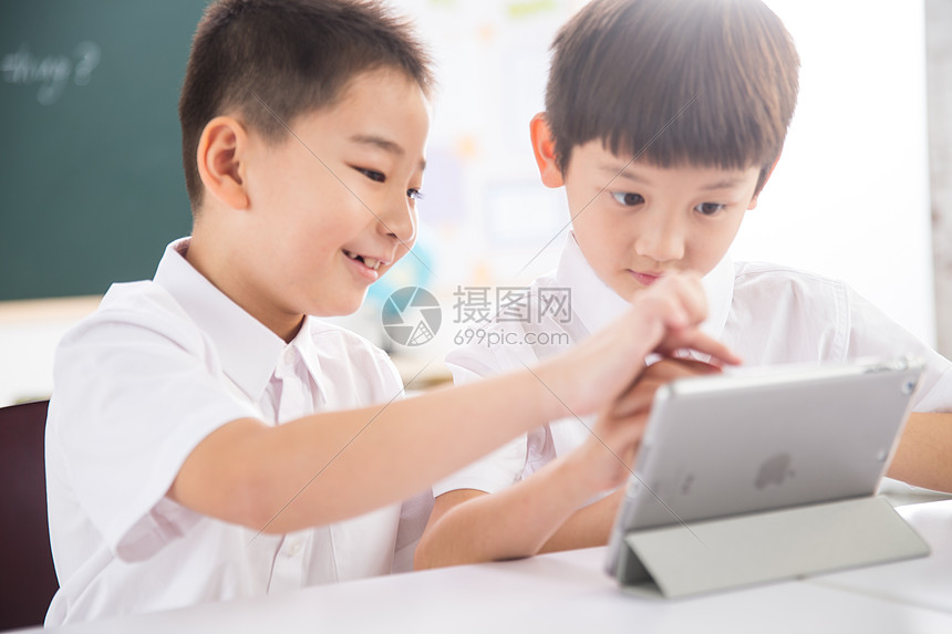 友谊无忧无虑乐趣两个小学生在使用平板电脑图片
