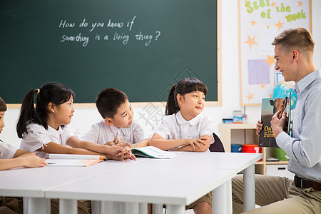 小学生上课讨论外教老师和小学生在教室里背景