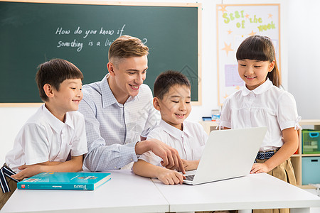 户内白昼可爱的教师和小学生在教室里高清图片