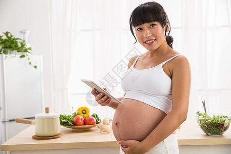 露出肚子孕妇看平板电脑图片