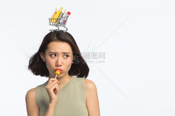 女东方人吃年轻女孩头顶购物车图片