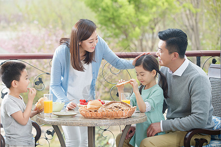 儿子幸福家庭在阳台吃早餐背景