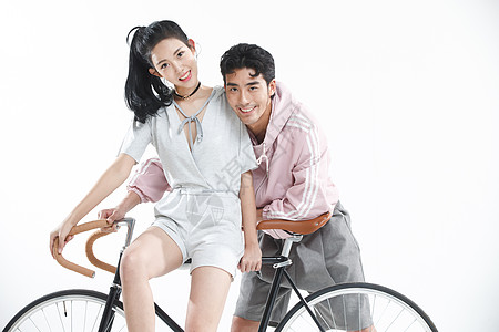 骑车出行情侣女朋友时尚影棚拍摄青年情侣骑自行车背景