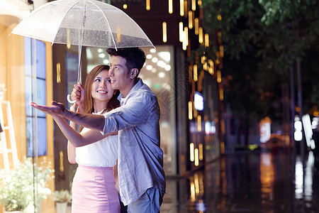 下雨天夜里一起逛街的情侣图片