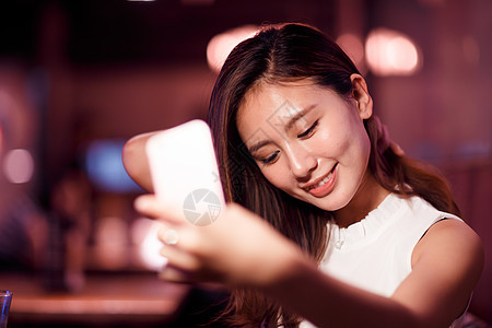光效果时尚人青年女人用手机自拍餐厅高清图片素材