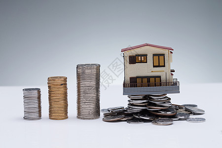 赚钱房地产金融硬币和房屋模型图片