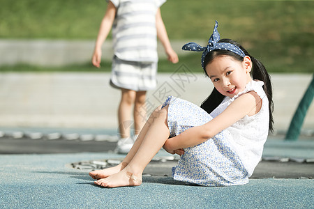 坐着玩耍女孩休闲活动坐着快乐儿童在户外玩耍背景