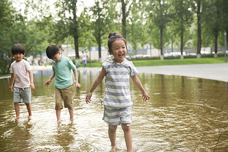 亚洲人相伴彩色图片快乐儿童在户外蹚水玩图片