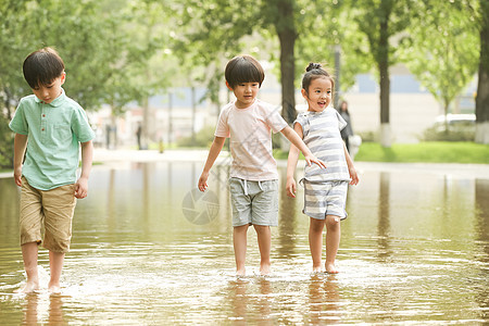 水池童年不看镜头快乐儿童在户外蹚水玩图片