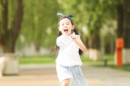 小女孩奔跑裙子发饰快乐小女孩在户外玩耍背景