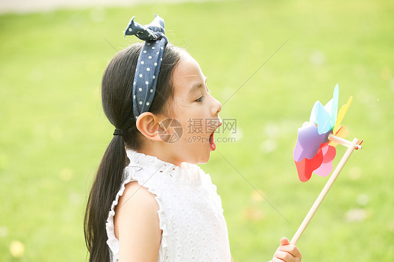 不看镜头高兴风车小女孩在户外玩耍图片