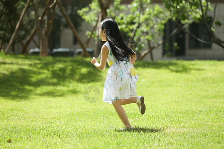 快乐休闲装东方人小女孩在户外玩耍高清图片