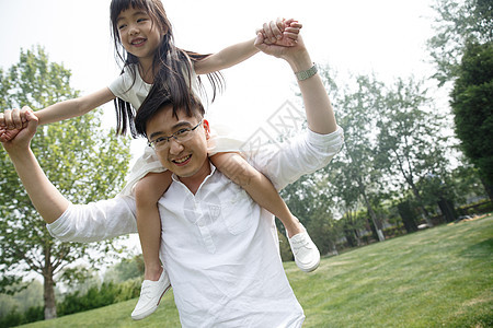郊游亚洲人绿色父亲驮着女儿在户外玩耍图片