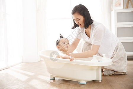 独生子家庭嬉戏的香波妈妈给宝宝洗澡图片