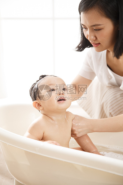 微笑东方人清洗妈妈给宝宝洗澡图片