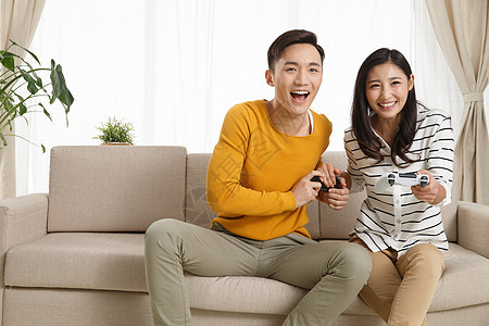 青年夫妇摄影两个人青年情侣坐着沙发上玩游戏图片