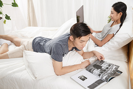 互联网女人亚洲人青年男人在床上看书高清图片