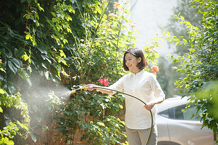 环保青年女人户外浇花高清图片