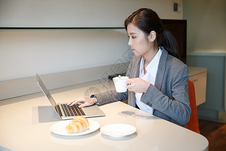 坐着现代青年女人吃早餐图片