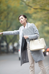 上班高峰运输等车商务人士青年女人在路边等出租车背景