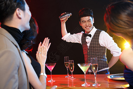 服务业职位光效果高脚杯青年男女在酒吧喝酒背景图片