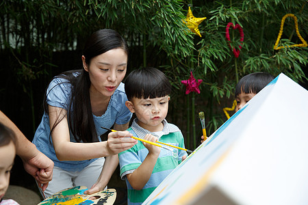 男孩生长幼儿园的师生在做手工高清图片