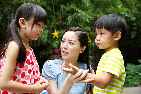 游乐场儿童幼儿园里教师在安慰受伤的儿童背景