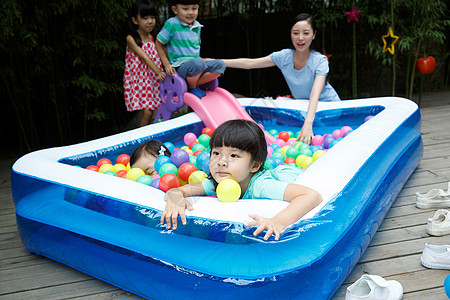 小孩游泳女球天真的幼儿园儿童和教师在户外玩耍背景