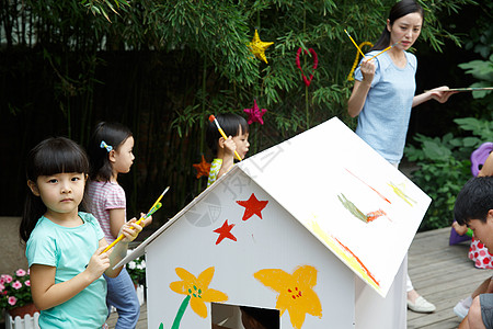 小孩嬉戏幼儿园的师生在做手工背景