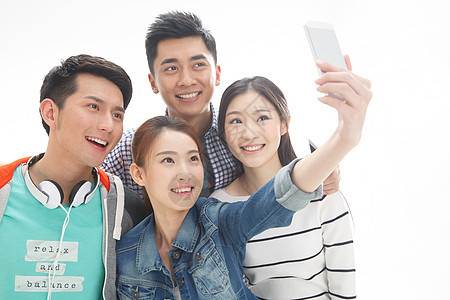 户内成功亚洲人四个的大学生使用手机拍照图片