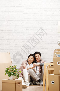 快乐青年人装修年轻夫妇坐在地板上休息图片
