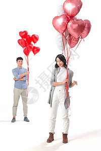 女人注视镜头全身像浪漫情侣拿着心形气球图片