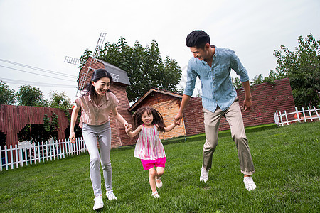 休闲活动东方人女儿快乐家庭在草地上奔跑图片