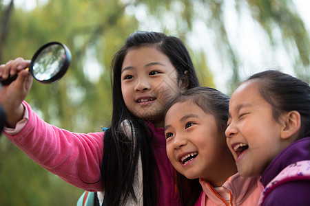 小女孩在拍照乐趣姐妹观察欢乐的小女孩在户外玩耍背景