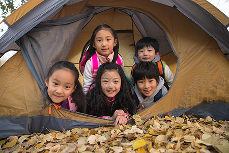 趴着玩小学生在户外露营背景