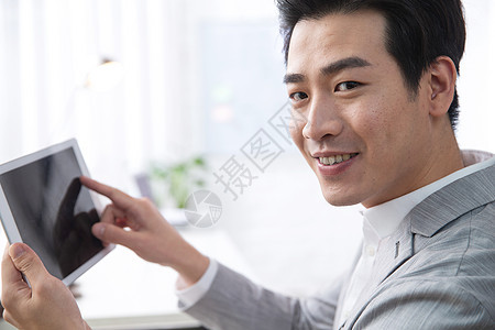 办公区商务人士电子商务青年商务男人拿着平板电脑办公图片