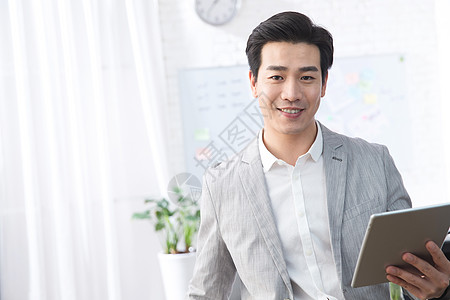 互联网行政人员办公室青年商务男人拿着平板电脑办公图片