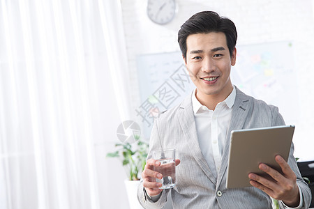 互联网白昼欢乐青年商务男人拿着平板电脑办公背景图片
