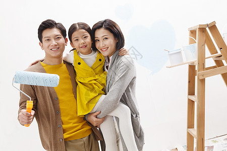 青年夫妇抱着孩子快乐家庭装修房子图片