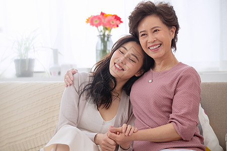 坐着优雅女人庆祝起居室坐着幸福母女背景